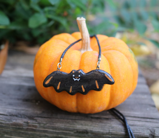 Bat Necklace in orange color-way shown on a pumpkin