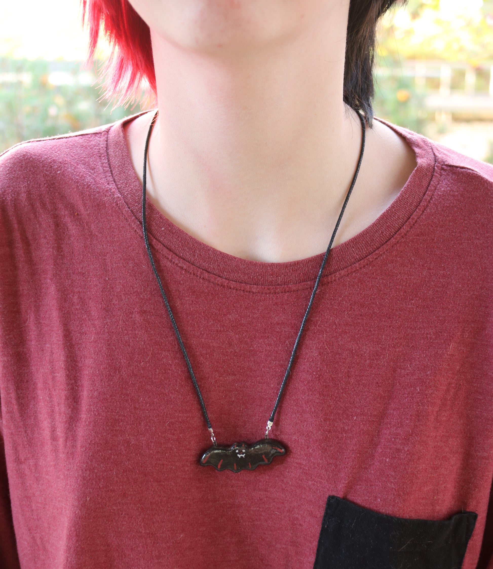 Bat Necklace in red color-way shown on a model